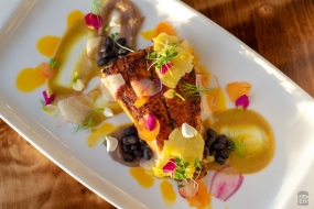 A photo of grilled sea bass with pineapple and beans